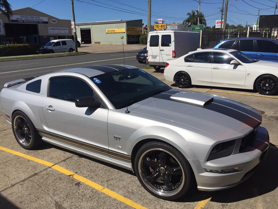 A silver car parked outside near the Tyre Select workshop.